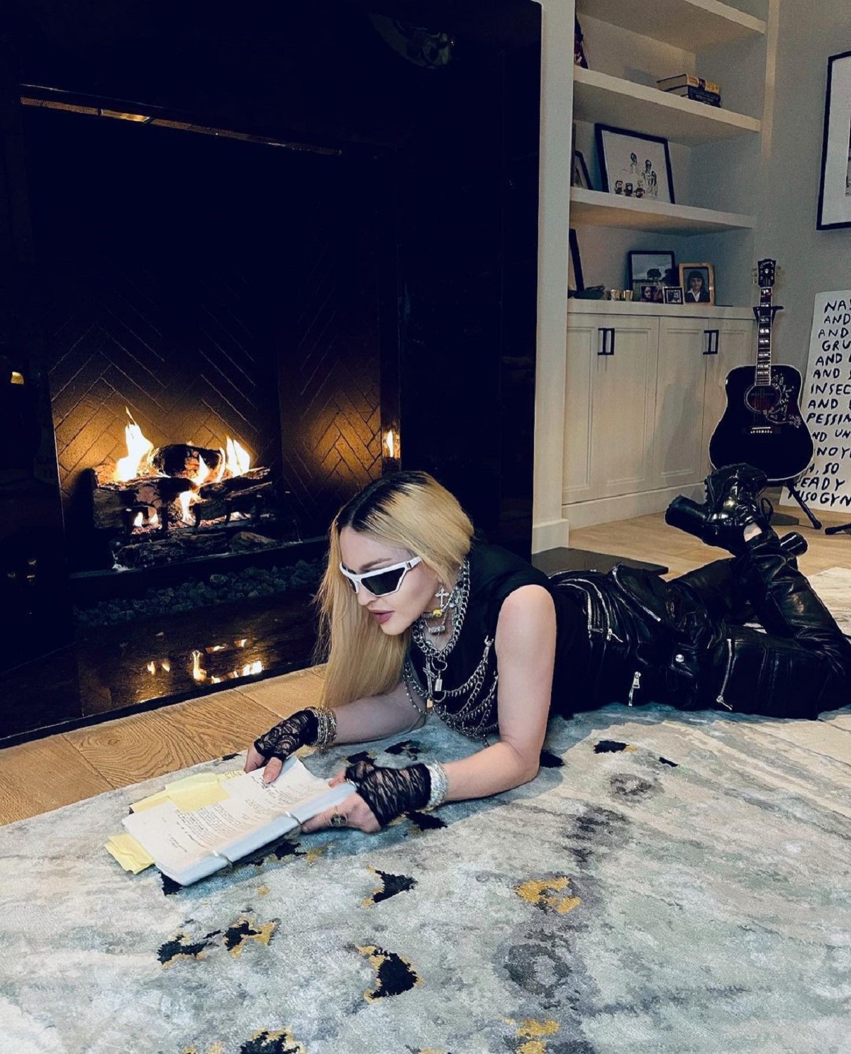 Madonna întinsă pe un covor în timp ce citește un contract