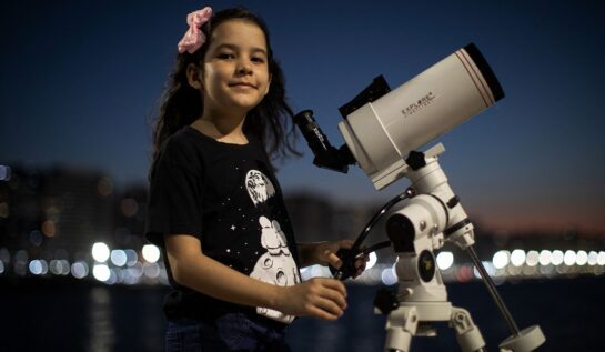 Nicole Oliveira e cea mai tânără astronomă din lume, la doar 8 ani. Ea colaborează cu un proiect NASA. În imagine poartă un tricou negru, o fundă roz, și se uită printr-un telescop alb