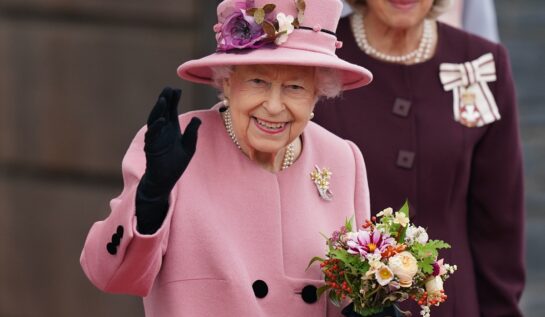 Regina Elisabeta într-un costum roz în timp ce ține în mâini un buchet de flori înainte de momentul în care a fost internată la spital