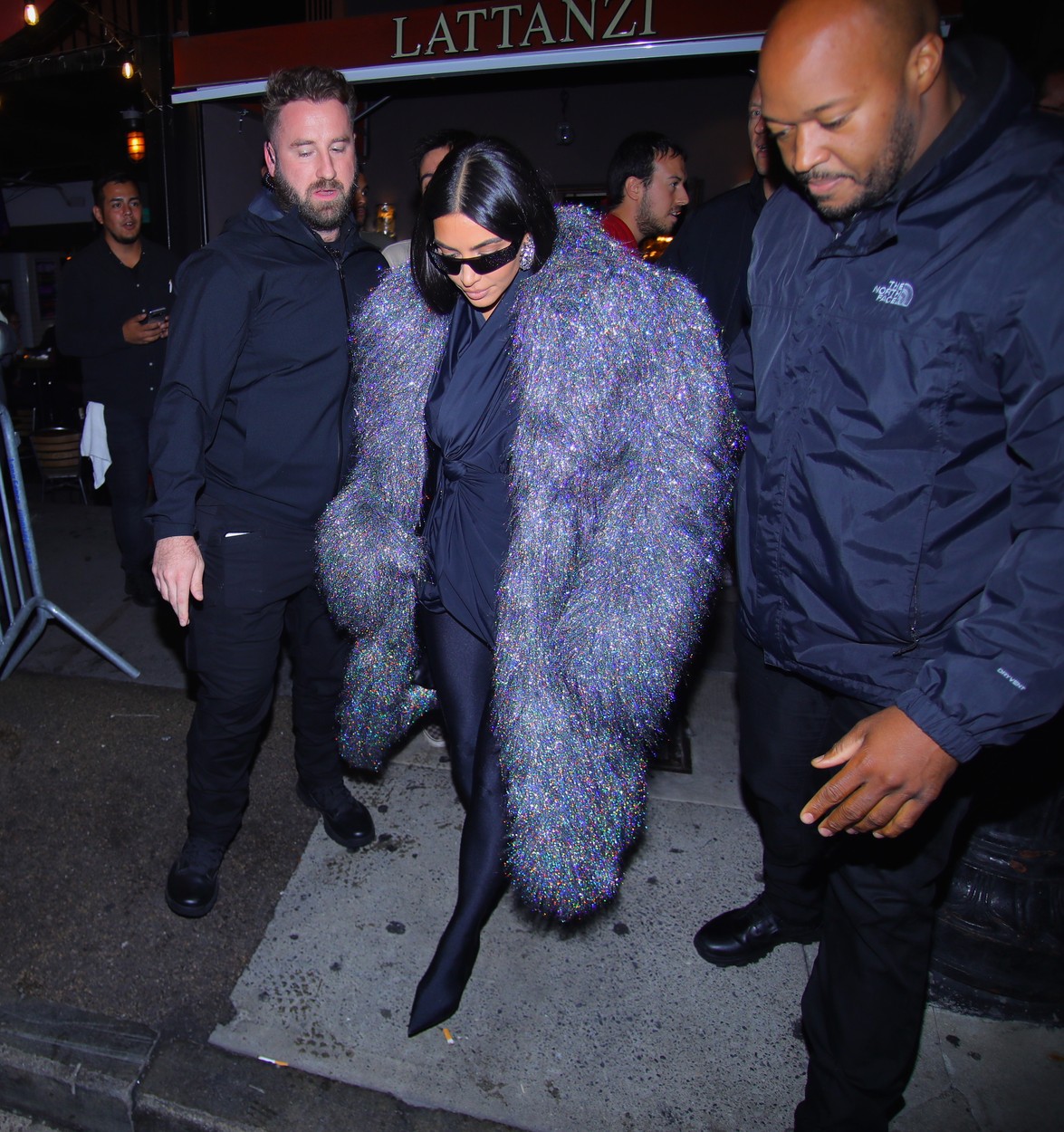 Kim Kardashian, înconjurată de gărzile de corp, la intrarea unui restaurant celebru