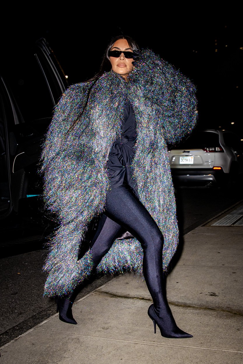Kim Kardashian, într-o haină excentrică, închisă la culoare, la o cină în oraș