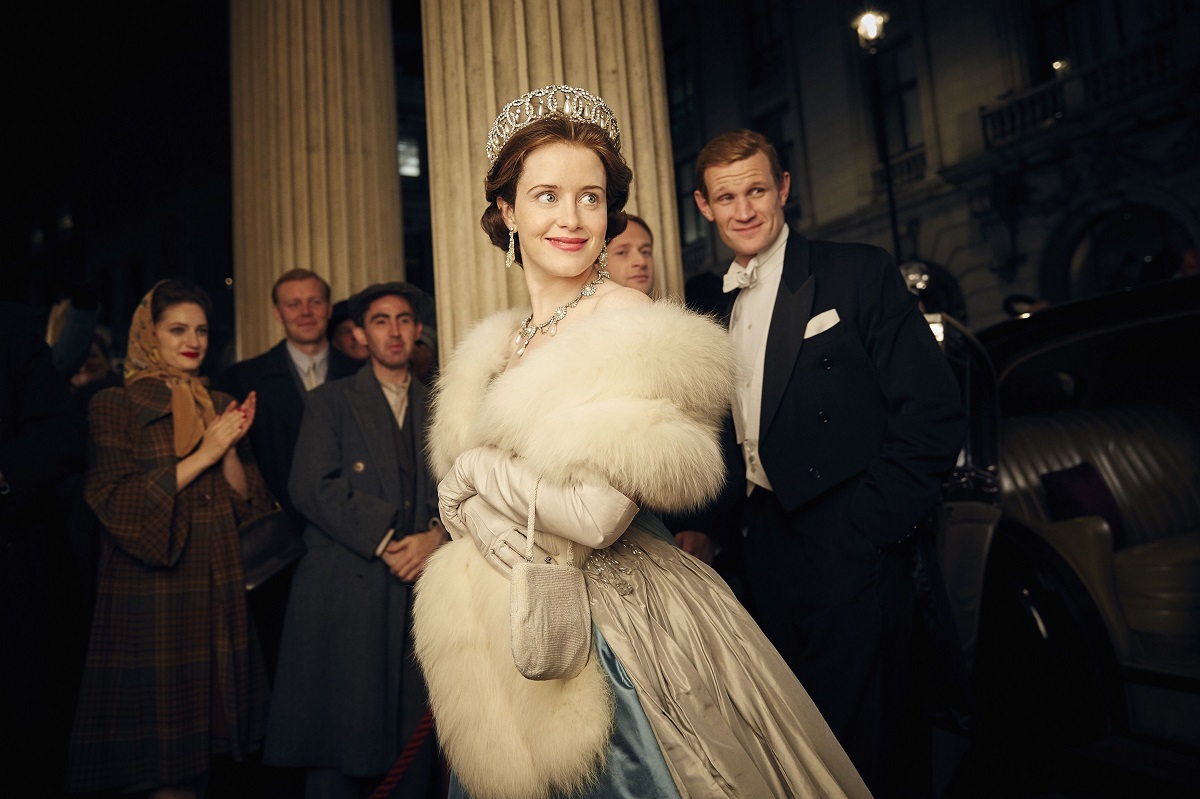 Matt Smith și Claire Foy i-au jucat e Prințul Philip și Regina Elisabeta în primele două sezoane ale serialului The Crown. Ea poartă o rochie albastră, cu o jachetă de blană albă și are coroana pe cap. Matt Smith e îmbrăcat într-un costum negru, în spatele ei