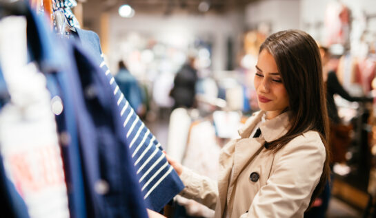 O femeie care se uită la hainele expuse într-un magazin
