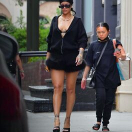 Rihanna într-un hanorac negru și o fustă scurtă cu blană în timp ce merge pe străzile din New York