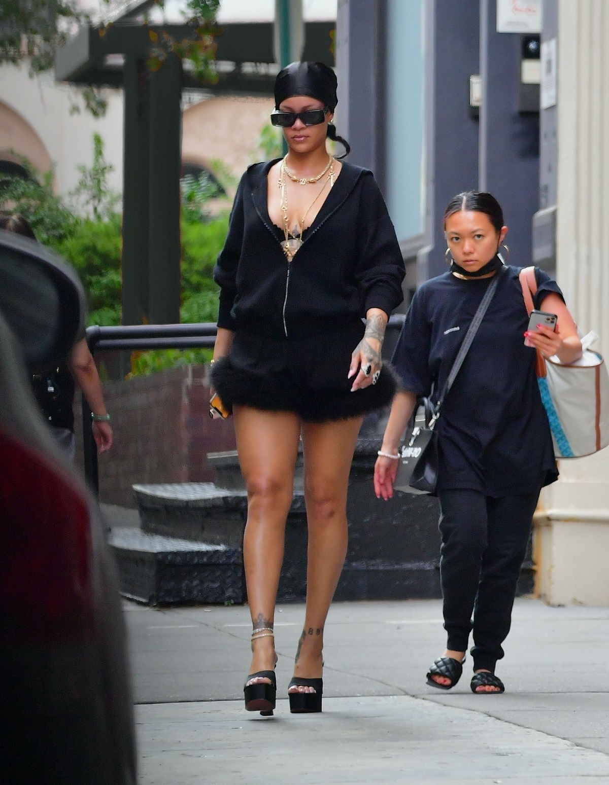 Rihanna într-un hanorac negru și o fustă scurtă cu blană în timp ce merge pe străzile din New York