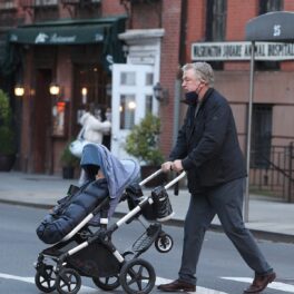 Alec Baldwin împingând la căruciorul copilului său pe o trecere de pietoni din New York