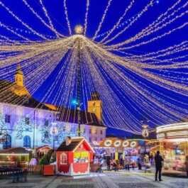 Unui din principalele târguri de Crăciun din România de la Sibiu cu luminițe în Piața Mare și căsuțe special amenajate