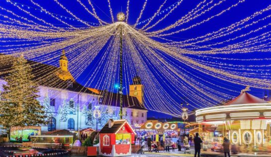 Unui din principalele târguri de Crăciun din România de la Sibiu cu luminițe în Piața Mare și căsuțe special amenajate
