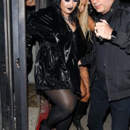 Demi Lovato într-o rochie mini neagră din piele în timp ce coboară niște scări la petrecerea din Los Angeles