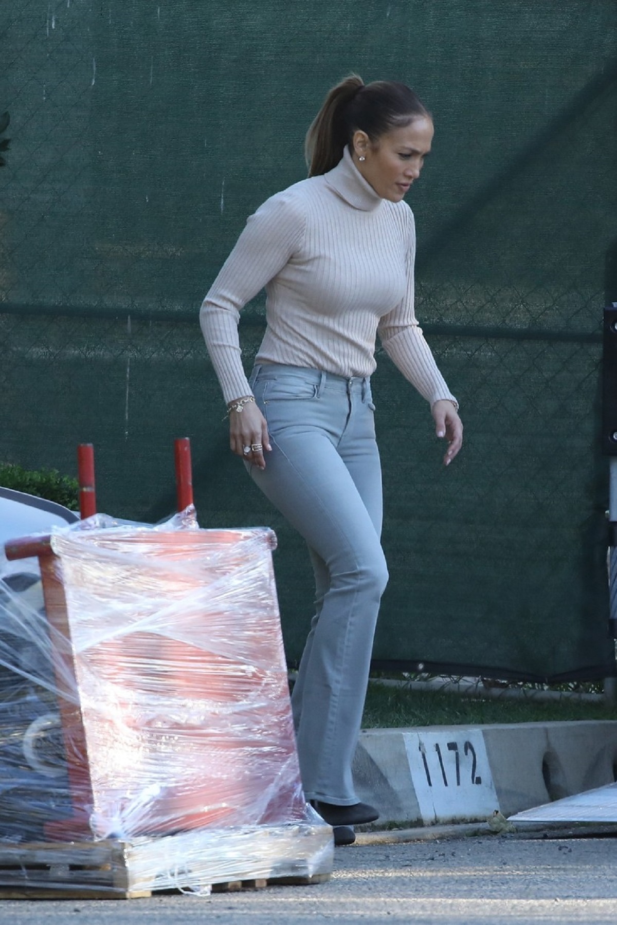 Jennifer Lopez într-o pereche de blugi gri și o maletă crem pe tocuri în fața casei lui Ben Affleck