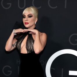 Lady Gaga într-o rochie neagră cu decolteu în timp ce pozează pe covorul roșu la turneul de promovare House of Gucci din New York 2021