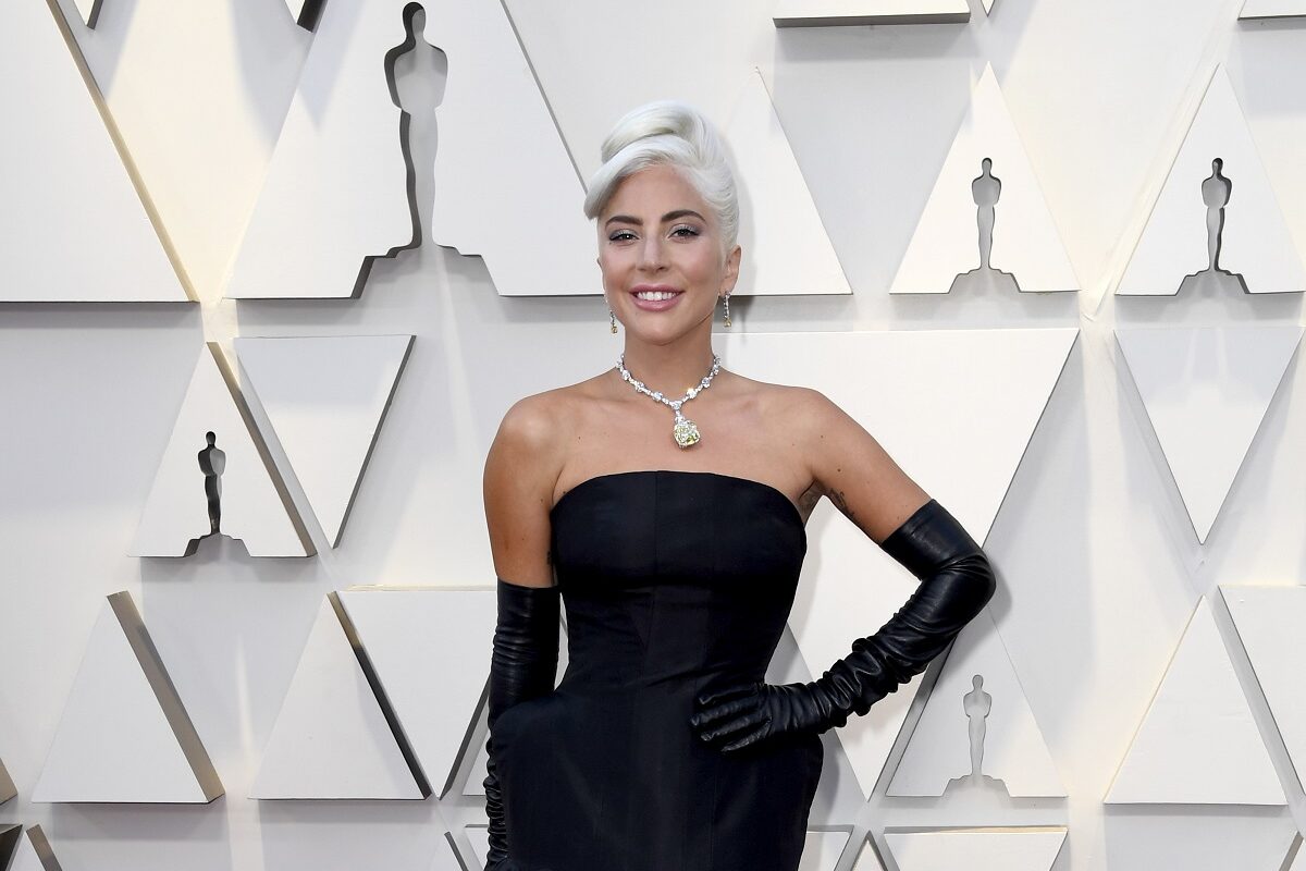Lady Gaga într-o rochie neagră mulată cu o pereche de mănuși lungi pe covorul roșu la Premiile Oscar din 2019