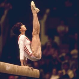 Nadia Comăneci executând un exercițiu la bârnă în 1976 la Jocurile Olimpice