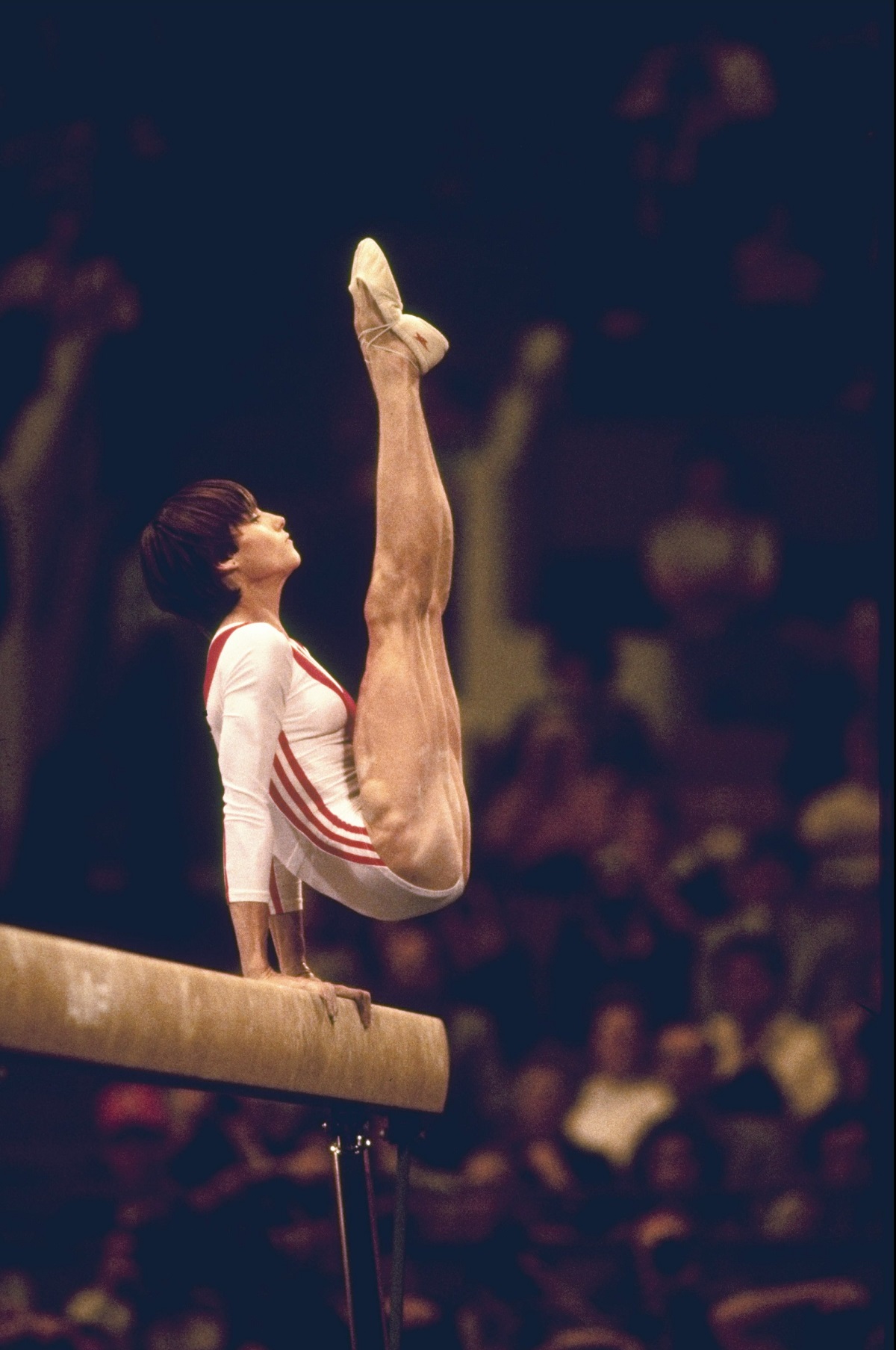Nadia Comăneci executând un exercițiu la bârnă în 1976 la Jocurile Olimpice