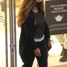 Serena Williams într-un tricou negru și o pereche de panaloni negri ieșind din mall