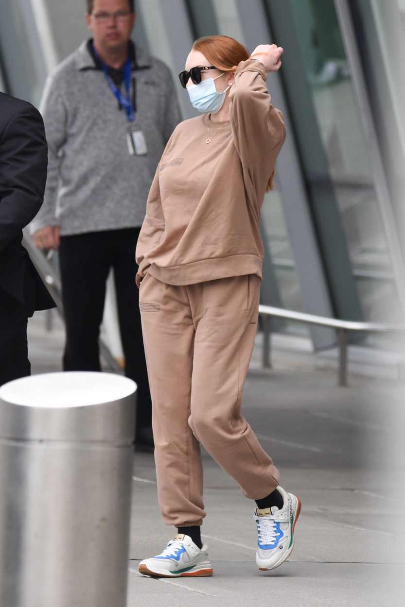 Lindsay Lohan, îmbrăcată în costum sport, pe un aeroport