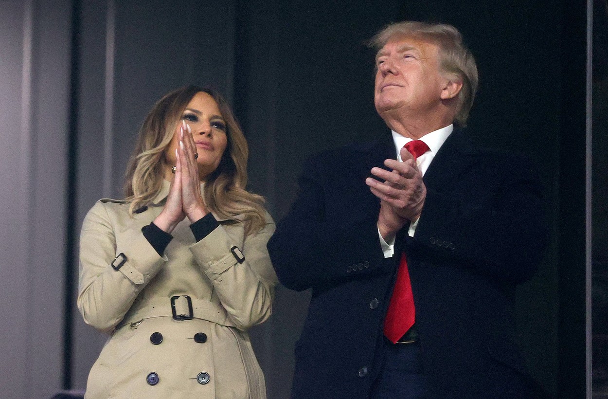 Melania Trump, zâmbitoare, aplaudând lângă soțul ei