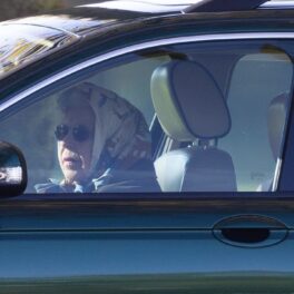 Regina Elisabeat la volanul unei mașini Jaguar în timp ce poartă ochelari de soare și un batic