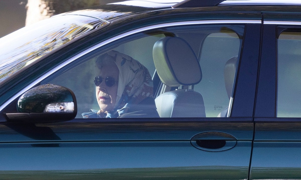 Regina Elisabeat la volanul unei mașini Jaguar în timp ce poartă ochelari de soare și un batic