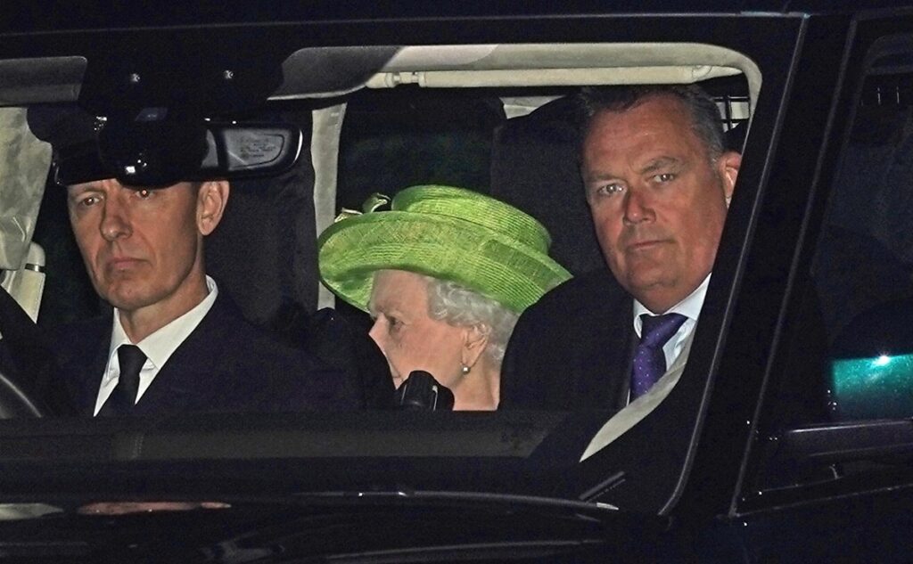 Regina Elisabeta într-un costum verde în mașină în timp ce vine la botezul strănepoților săi