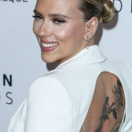 Scarlett Johansson, într-un costum alb, cu spatele gol, zâmbind la camere