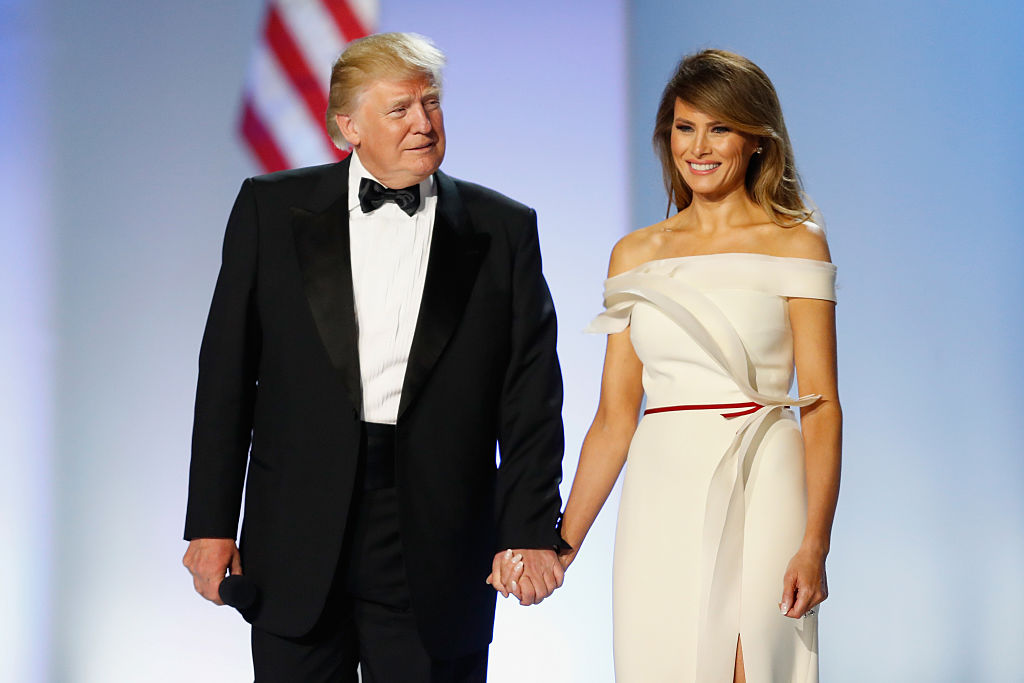 Donald Trump, în timp ce o ține de mână pe Melania Trump, la Freedom Ball, în 2020