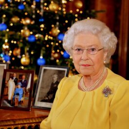 Regina Elisabeta într-o bluză galbenă în fața biroului la Castelu Windsor de Crăciun în anul 2013
