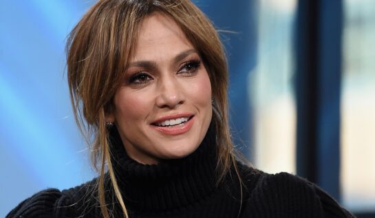 Jennifer Lopez într-o bluză neagră cu părul prins în timpul unui interviu din 2019