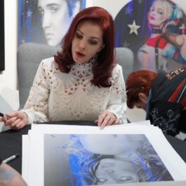 Priscilla Presley în timp ce semnează un autoportret realizat de artistul Adam Rote