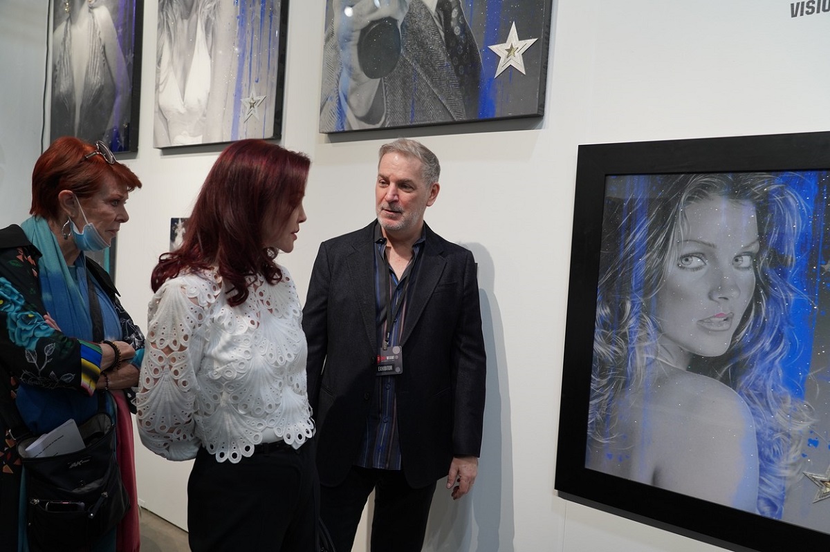 Priscilla Presley în timp ce privește un portret cu ea în tinerețe realizat de Adam Rote