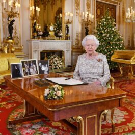 Regina Elisabeta în fața unui birou de Crăciun în timp ce stă la poza tradițională de Crăciun