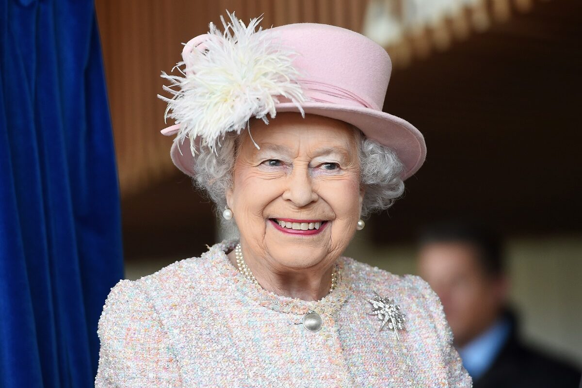 Regina Elisabeta într-un costum alb cu pălărie la ceremonia de Crăciun