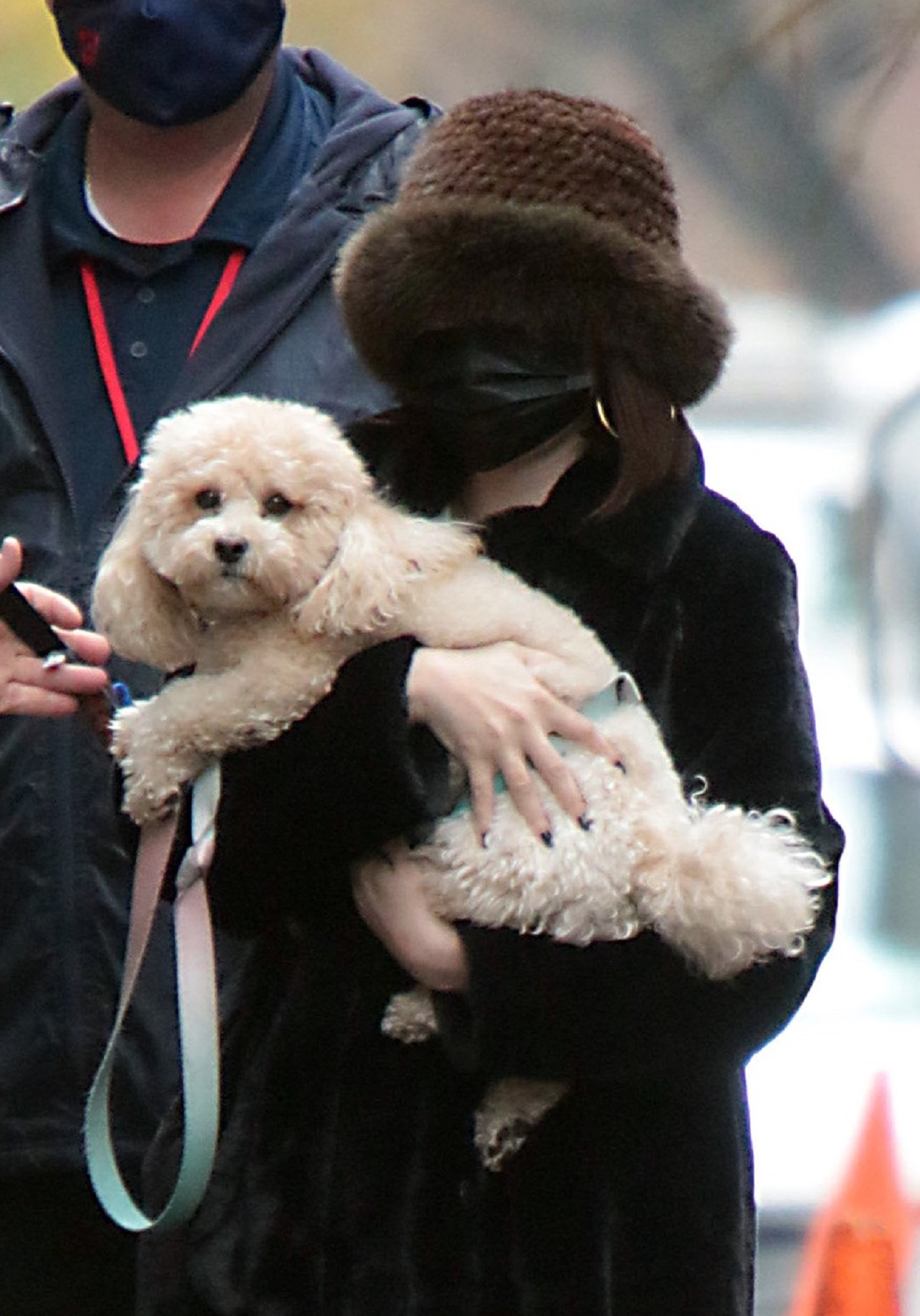 Selena Gomez la plimbare cu o căciulă pe cap și un câine alb în brațe