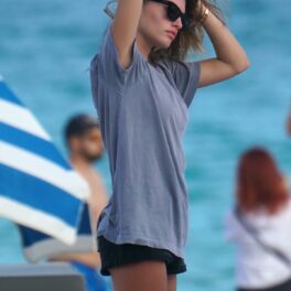 Thylane Blondeau în timp ce își aranjează părul și poartă un tricou albastru și o pereche de pantaloni scurți negri la plajă în Miami