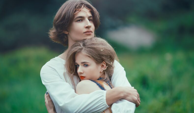 Un tânăr și o tânără care se țin în brațe într-o pădure pentru a reprezenta una din cele trei zodii care vor petrece revelionul singure