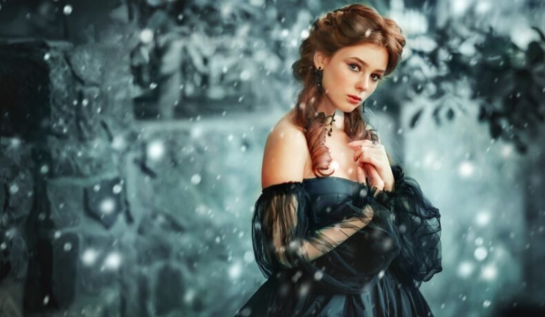 O femeie frumoasă care poartă o rochie neagră în timp ce stă într-un cadru de iarnă pentru a reprezenta una din cele trei zodii norocoase în ziua de 2 ianuarie 2022