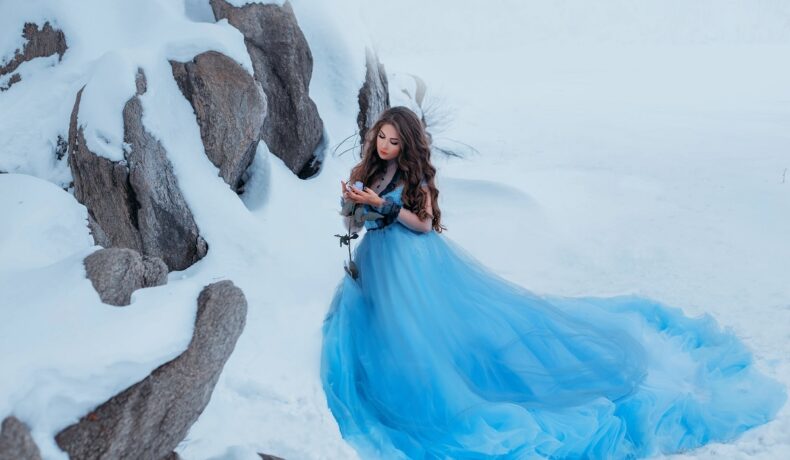 O femeie frumoasă într-o rochie albastră pe munte în timp ce reprezintă una din cele trei zodii norocoase în ziua de 3 decembrie 2021