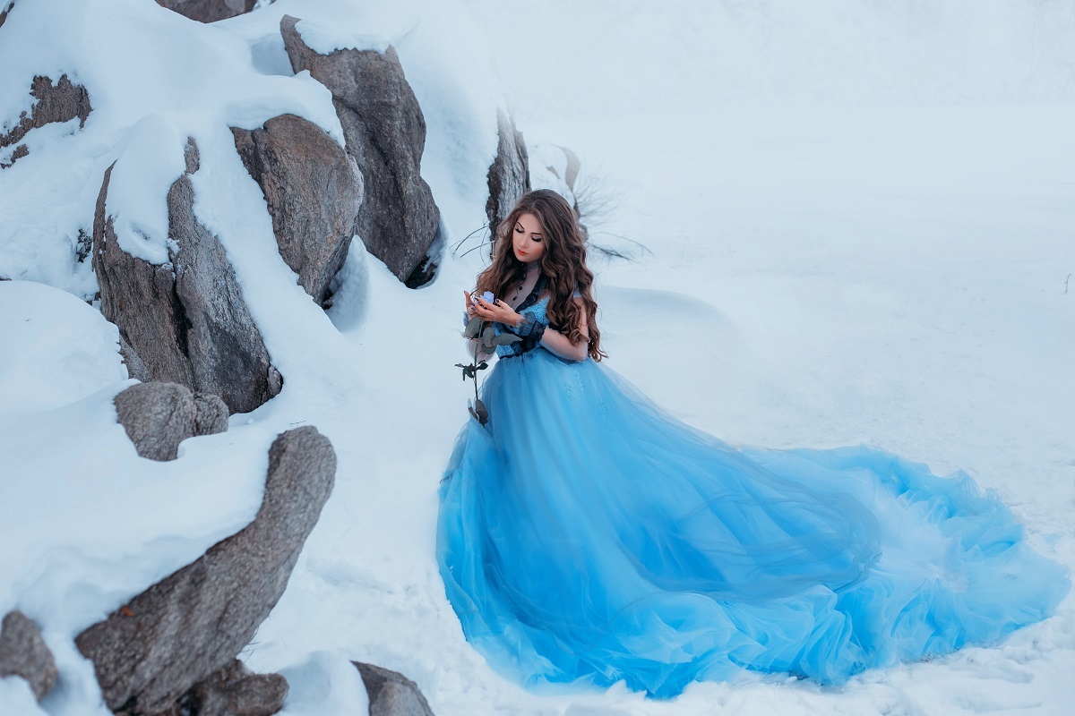 O femeie frumoasă într-o rochie albastră pe munte în timp ce reprezintă una din cele trei zodii norocoase în ziua de 3 decembrie 2021