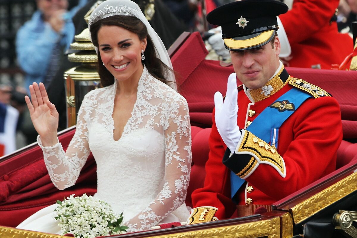 Kate Middleton și Prințul William în timp ce fac cu mâna publicului dintr-o trăsură la nunta lor