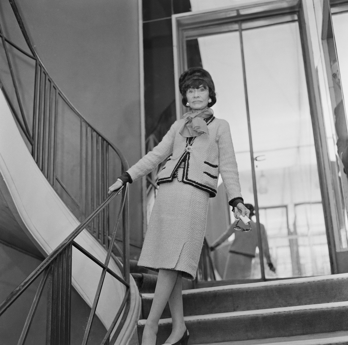 Coco Chanel într-un costum Chanel pe scări
