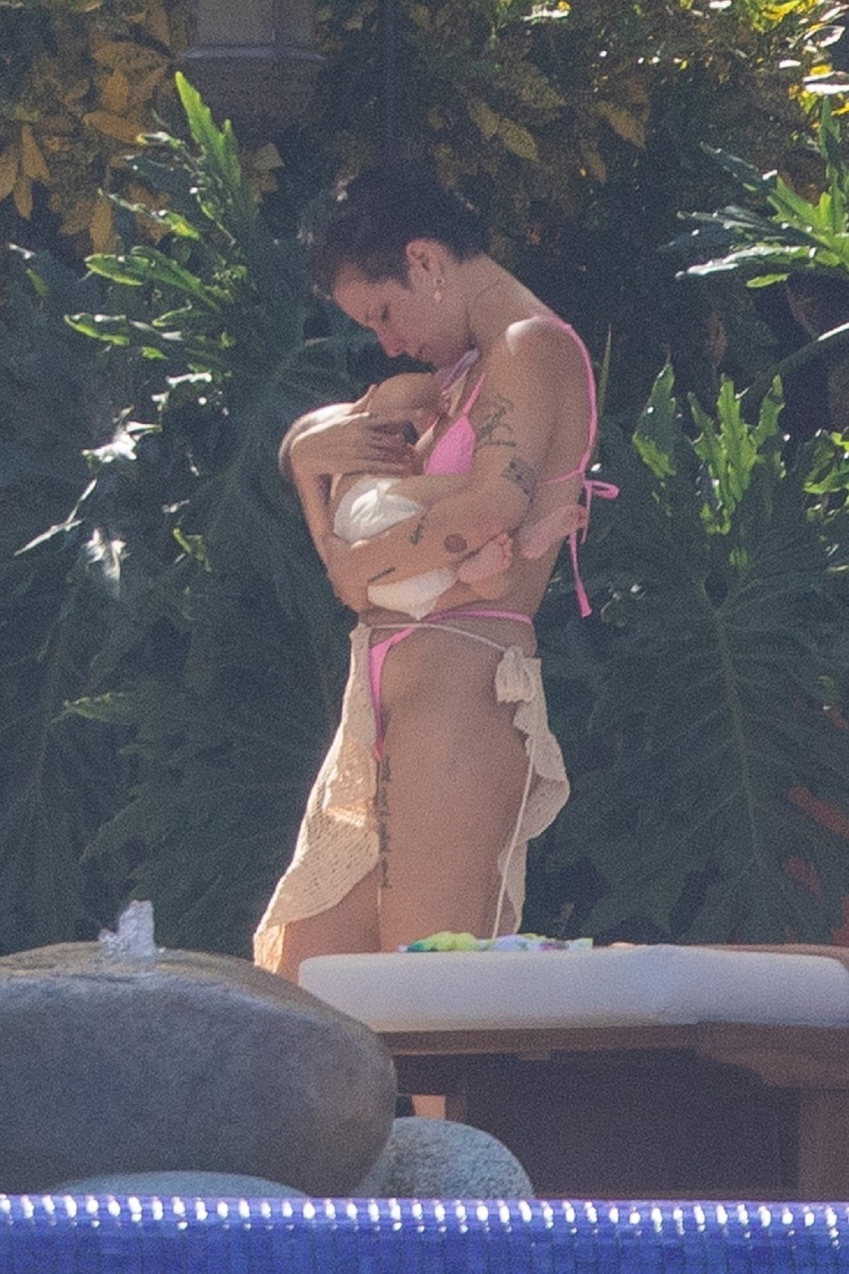 Halsey în costum de baie roz în timp ce își leagănă copilul