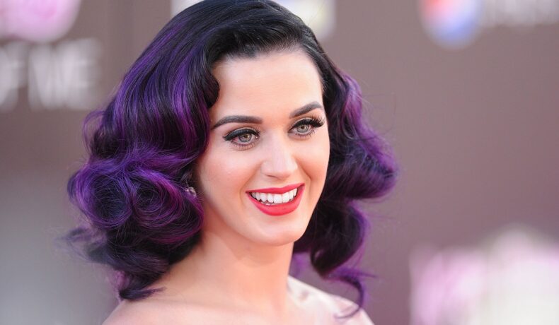 Katy Perry cu părul violet în timp ce zâmbește la cameră