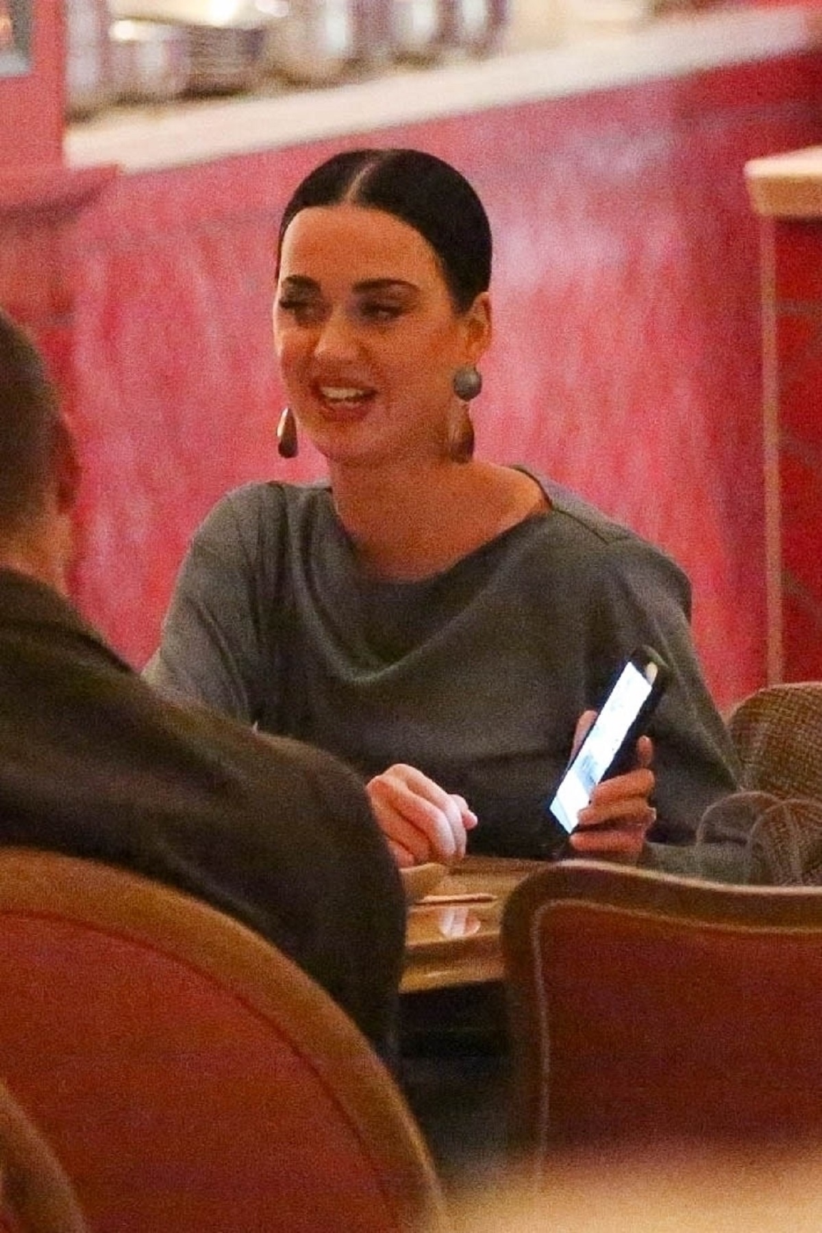 Katy Perry într-o rochie albastră în timp ce stă la masă