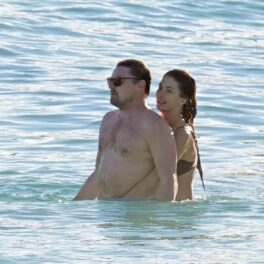 Leonardo DiCaprio în apă în timp ce este îmbrățișat de iubita sa, Camila Morrone