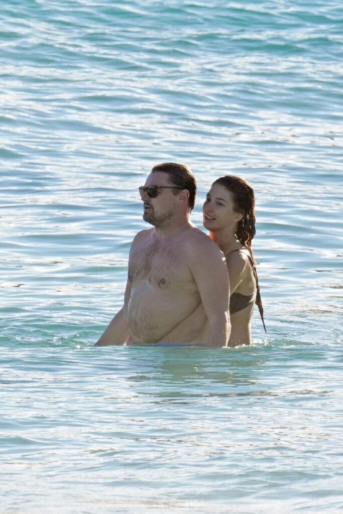 Leonardo DiCaprio în apă în timp ce este îmbrățișat de iubita sa, Camila Morrone
