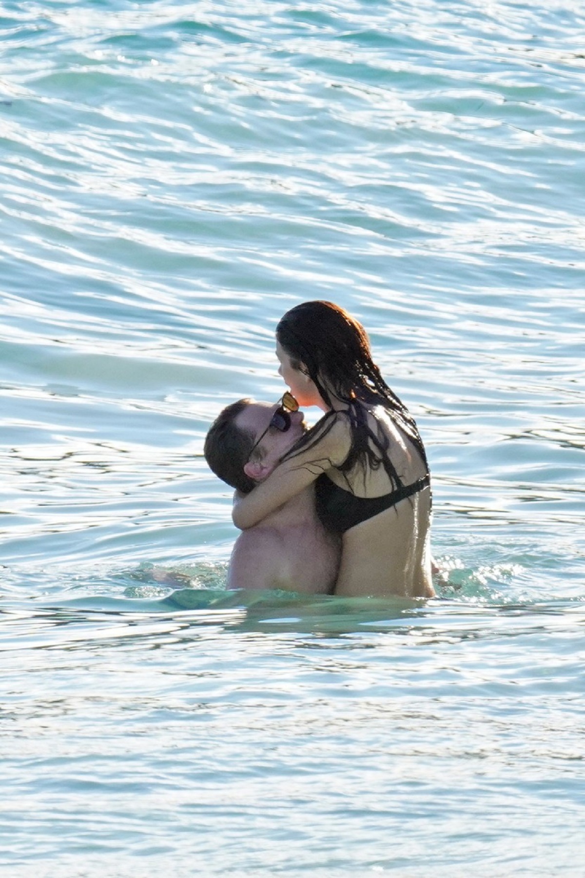 Leonardo DiCaprio în apă în timp ce o ține în brațe pe Camila Morrone