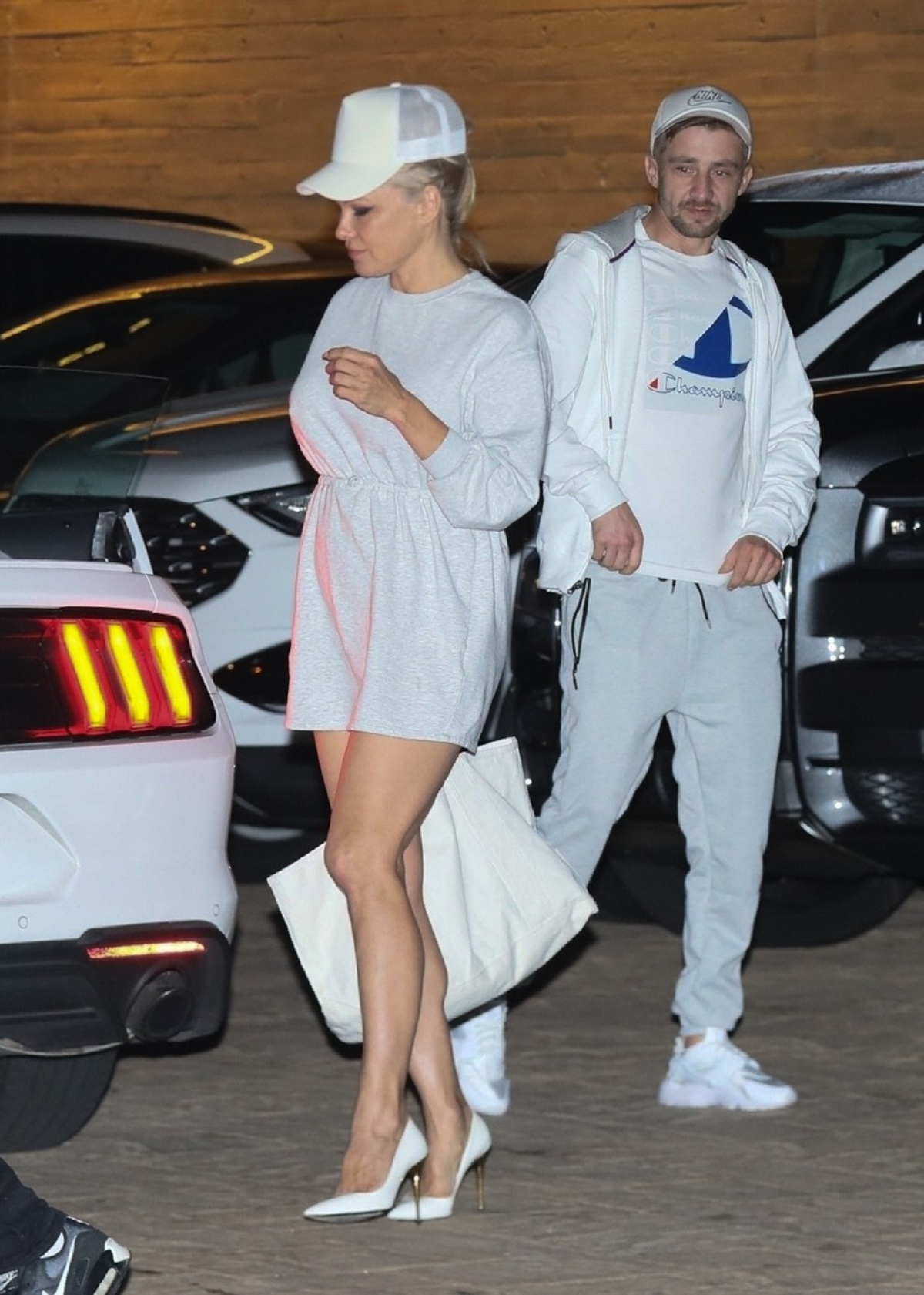 Pamela Anderson într-o parcare în timp ce merge la un restaurant de lux din Malibu și poartă o rochie scurtă albă