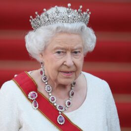 Regina Elisabeta într-o rochie labă cu o diademă din pietre rpețioase pe cap