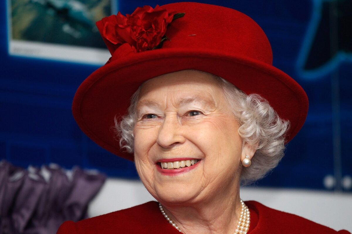 Regina Elisabeta într-un costum roșu cu o pălărie