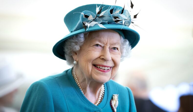 Regina Elisabeta într-un costum albastru cu pălărie într-o vizită oficială din Edinburgh în anul 2021